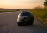 Kask motocyklowy na asfalcie przy drodze