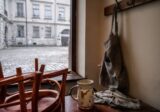 Pusta kawiarnia rano, krzesła na stole i fartuch na haczyku, podwórze kamienicy w Krakowie