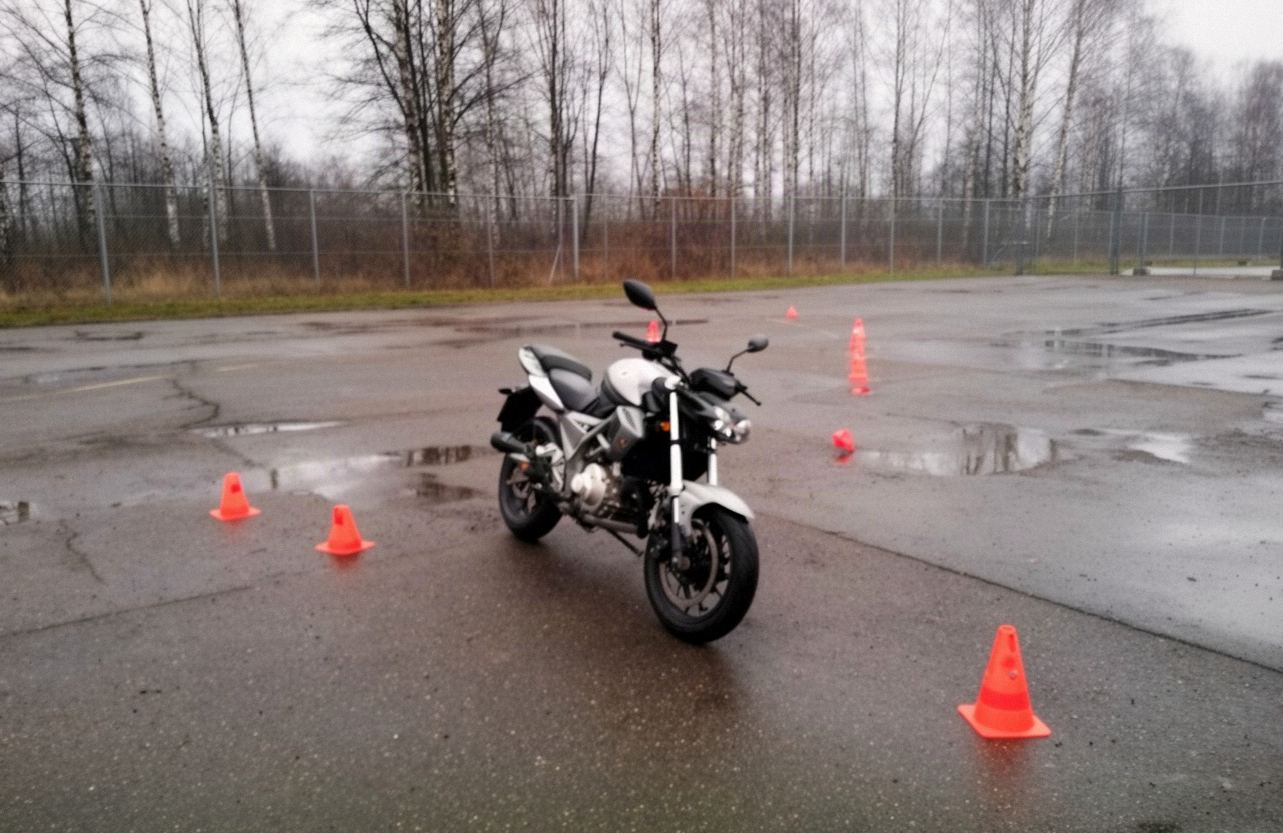 Lekki motocykl 125 cm³ na placu manewrowym z pachołkami do slalomu