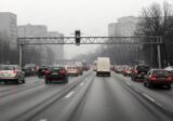 Ruch samochodów na wielopasmowej ulicy wlotowej w mglisty zimowy poranek